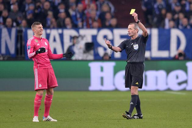 Fußball Champions League Achtelfinale Schalke 04 - Real Madrid am 18.02.2015 in der Veltins-Arena in Gelsenkirchen FIFA Schiedsrichter Martin Atkinson ( ENG ), rechts zeigt Toni Kroos ( Madrid ), links die Gelbe Karte