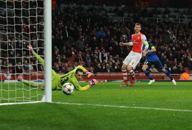 Football - 2014 2015 Champions League - Round of 16, First Leg: Arsenal vs. AS Monaco Yannick Ferreira Carrasco of Monaco scores goal no. 3 past Arsenal s David Ospina and Per Mertesacker at The Emirates. COLORSPORT ANDREW COWIE 