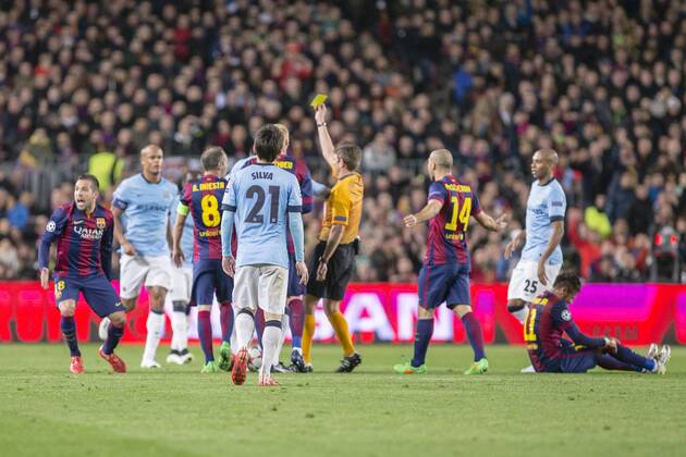 BARCELONA, SPAIN - MARCH 18: The referee Gianluca Rocchi shows the yellow card to Samir Nasri of Manchester City during the UEFA Champions League round of 16 match between FC Barcelona Barca and Manchester City at Camp Nou Stadium on March 18, 2015 in Barcelona, Spain. 