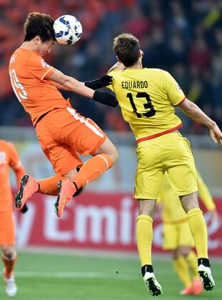 (150408) -- JINAN, April 8, 2015 -- Yang Xu (L) of China s Shandong Luneng FC heads the ball with Eduardo of Japan s Kashiwa Reysol during the group E match at the 2015 AFC Champions League in Jinan, east China s Shandong Province, April 8, 2015. ) (lm) (SP)CHINA-JINAN-AFC CHAMPIONS LEAGUE ZhuxZheng 