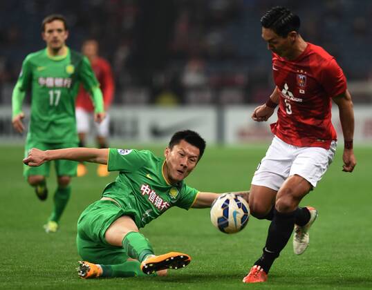 (150408) -- SAITAMA, April 8, 2015 -- Zhou Ting (bottom) of China s Beijing Guoan vies with Tomoaki Makino of Japan s Urawa Red Diamonds during their group E match at the 2015 AFC Champions League in Saitama, Japan, April 8, 2015. The match ended with a 1-1 draw. ) (SP)JAPAN-SAITAMA-AFC CHAMPIONS LEAGUE-GROUP G-URAWA REDS VS BEIJING GUOAN Stringer 