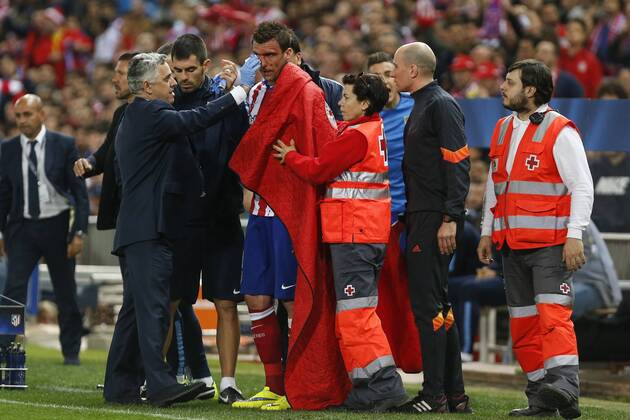 Atletico de Madrid s Mario Mandzukic gets injured with his face covered in blood during quarterfinal first leg Champions League soccer match at Vicente Calderon stadium in Madrid, Spain. April 14, 2015.  (2015041400072)