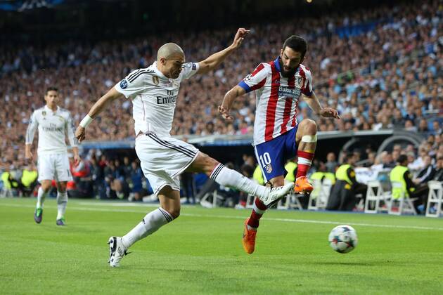 Pepe of Real Madrid clears from an attacking Arda Turan of Atletico - Real Madrid vs. Atletico Madrid - UEFA Champions League - Quarter Final Second Leg - Santiago Bernabeu - Madrid - 22 04 2015 Pic Philip Oldham Sportimage EDITORIAL USE ONLY. No use with unauthorised audio, video, data, fixture lists, club league logos or live services. Online in-match use limited to 120 images, no video emulation. No use in betting, games or single club league player publications.