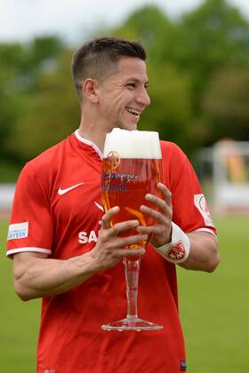 v.li.: Amir Shapourzadeh (FC Würzburger Kickers) mit Biertulpe, Bierglas, nach dem Spiel, Freude, freundlich, fröhlich, strahlend, optimistisch, Fussball, Regionalliga Bayern, VfR Garching - FC Würzburger Kickers, xslx