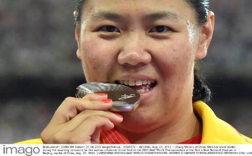 (150827) -- BEIJING, Aug. 27, 2015 -- Zhang Wenxiu of China bites her silver medal during the awarding ceremony for the women s hammer throw final at the 2015 IAAF World Championships at the Bird s Nest National Stadium in Beijing, capital of China, Aug. 27, 2015. ) (SP)CHINA-BEIJING-IAAF WORLD CHAMPIONSHIPS--WOMEN S HAMMER THROW-AWARDING CEREMONY (CN) LixWen 