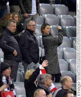 29.09.2015, Fussball Championsleague 2015 2016, Vorrunde, 2.Spieltag, FC Bayern München - Dinamo Zagreb, in der Allianz-Arena München. Bildserie, 1.v.4: re: Anna, die Ehefrau von Robert Lewandowski (Bayern München) auf der Tribüne, signalisiert nach dem Schlusspfiff seinem Mann auf dem Platz den Treffpunkt nach dem Spiel oben... 