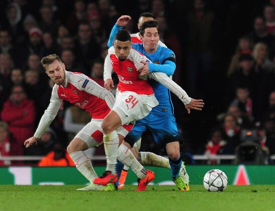 Football - 2015 2016 Champions League - Round of 16, First Leg: Arsenal vs. Barcelona Lionel Messi of Barcelona is challenged by Aaron Ramsey and Francis Coquelin at The Emirates. COLORSPORT ANDREW COWIE