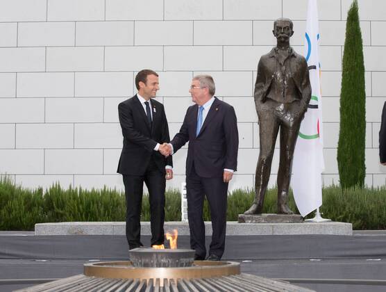 (170711) -- LAUSANNE, July 11,2017 -- French President Emmanuel Macron (L) and International Olympic Committee (IOC) President Thomas Bach shake hands in front of the Pierre de Coubertin statue at Olympic Museum in Lausanne, Switzerland, July 10, 2017. Members of IOC will hold a session for presentations by the campaign teams for Los Angeles and Paris on July 11th and 12th. ) (SP)SWITZERLAND-LAUSANNE Olympic Games Olympische Spiele Olympia OS 2024 BID XuxJinquan 
