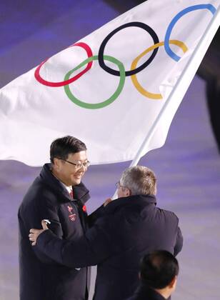 Pyeongchang Olympics International Olympic Committee President Thomas Bach (R) hands over the Olympic flag to Beijing Mayor Chen Jining during the closing ceremony of the Winter Olympics at the Pyeongchang Olympic Stadium in South Korea on Feb. 25, 2018. 