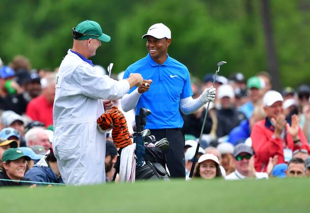 Tiger Woods fist bumps his caddie Joe LaCava after hitting on the 11th tee during the third round of the 2018 Masters Tournament at the Augusta National Golf Club in Augusta, Georgia, on April 7, 2018.  AUG20180407308 KEVINxDIETSCH