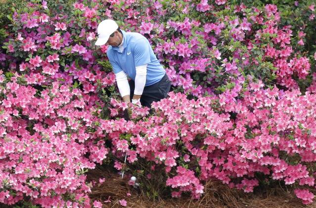 Rory McIlroy of Northern Ireland hits his golf ball out of a pack of azalea plants behind the 13th green in the 3rd round of the 2018 Masters Tournament at the Augusta National Golf Club in Augusta, Georgia, on April 7, 2018.  AUG20180407122 JOHNxANGELILLO