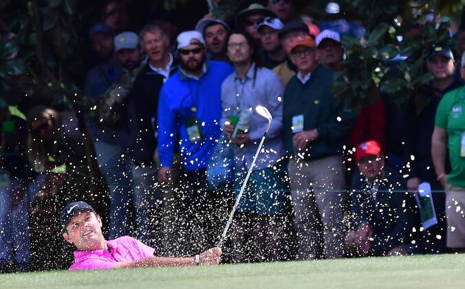Patrick Reed hits out of a bunker on the 1st hole in the final round of the 2018 Masters Tournament at the Augusta National Golf Club in Augusta, Georgia, on April 8, 2018.  AUG20180408105 KEVINxDIETSCH