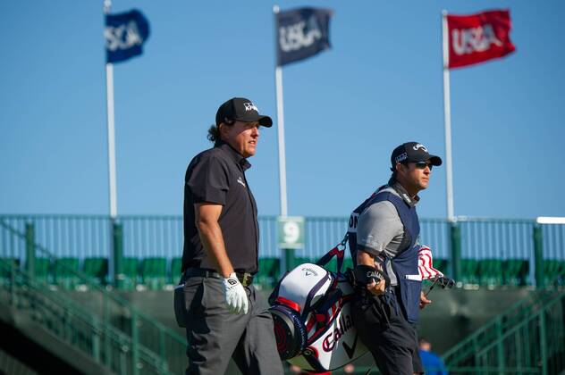 Phil Mickelson from the United States and caddy Tim Mickelson walk on the 10th fairway in the first round of the 118th U.S. Open Championship at Shinnecock Hills Golf Club in Southampton, New York on June 14, 2018.  NYP20180614109 COREYxSIPKIN