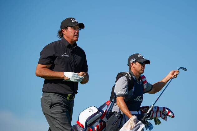Phil Mickelson with caddy Tim Mickelson walk on the 11th fairway in the first round of the 118th U.S. Open Championship at Shinnecock Hills Golf Club in Southampton, New York on June 14, 2018.  NYP20180614122 COREYxSIPKIN