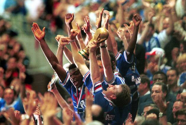 Fußball Fussball Weltmeisterschaft France 98 Finale Endspiel Paris-Saint-Denis Stade France 12.07.1998 Nationalmannschaft Frankreich Didier Deschamps mit Pokal dahinter die Mannschaft Jubel Oberkörper Oberkoerper Freude Emotion Kapitän Kapitaen Arme Siegerehrung