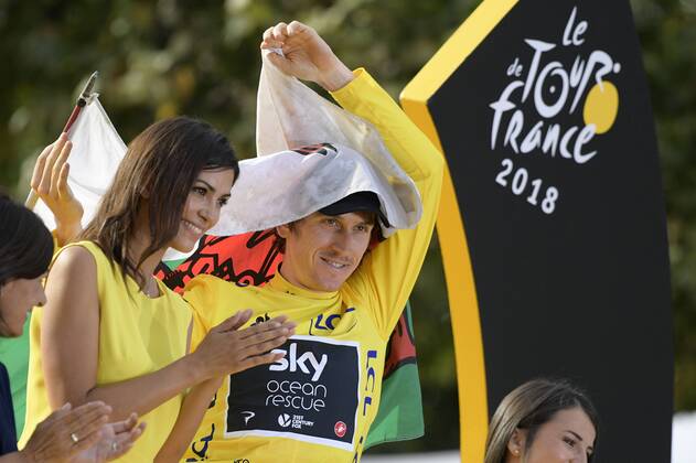 British Geraint Thomas of Team Sky wearing the yellow jersey of overall leader, carrying a Welsh flag, celebrates on the podium after the last stage of the 105th edition of the Tour de France cycling race, 116km from Houilles to Paris, France, Sunday 29 July 2018. This year s Tour de France takes place from July 7th to July 29th. YORICKxJANSENS  x05395079x