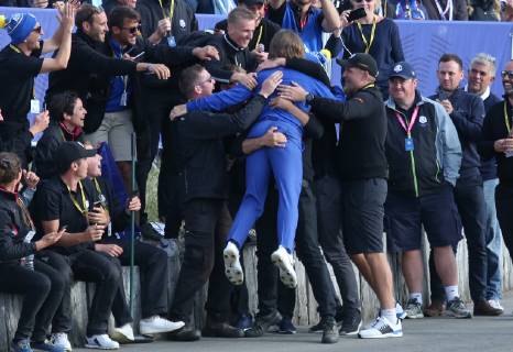 Tommy Fleetwood celebrates with green keepers after Team Europe clinched the Ryder Cup at Le Golf National in Guyancourt near Paris on September 30, 2018. Team Europe defeated Team USA 17.5 to 10.5 to hand the Americans their sixth straight loss on foreign soil.  PAR20180930056 DAVIDxSILPA