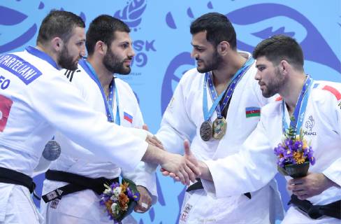 MINSK, BELARUS - JUNE 24, 2019: Athletes Varlam Liparteliani of Georgia, Arman Adamian of Russia, Elmar Gasimov of Azerbaijan and Cyrille Maret (L-R) of France shake hands at a victory ceremony after the men s haf-heavy weight (-100kg) gold medal bout at the 2nd Europaspiele Natalia Fedosenko TASS  TS0B0C5E