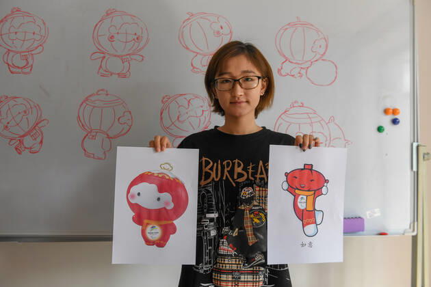 (190926) -- CHANGCHUN, Sept. 26, 2019 -- Designer Jiang Yufan shows Shuey Rhon Rhon, the mascot of the 2022 Paralympic Winter games, Winterspiele,Spiele, Summer games and Ruyi, its original sketch, at Jilin University of Arts in Changchun, northeast China s Jilin Province on Sept. 26, 2019. Shuey Rhon Rhon, the mascot of the 2022 Paralympic Winter Games, is a Chinese lantern child ready to welcome friends from around the world for a big party. Exuding positivity, the glow emanating from its heart symbolises the inspiring warmth, friendship, courage and perseverance of Para athletes that light up the dreams of millions every day. ) (SP)JILIN-CHANGCHUN-2022 PARALYMPIC WINTER GAMES-MASCOT ZhangxNan