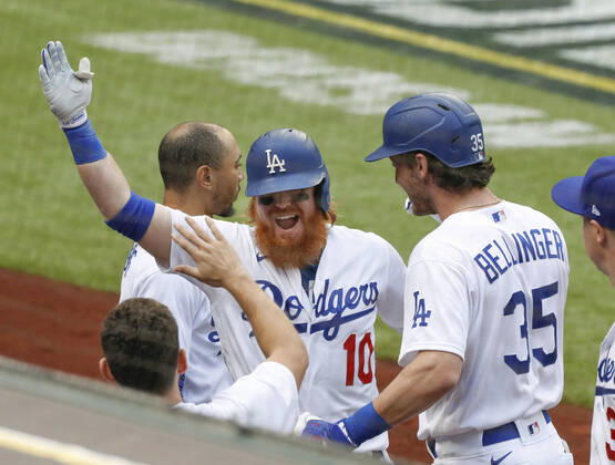 Baseball: NL Championship Series Justin Turner (10) of the Los Angeles Dodgers is congratulated by teammates after hitting a solo home run in the first inning in Game 6 of the NL Championship Series against the Atlanta Braves on Oct. 17, 2020, in Arlington, Texas. 