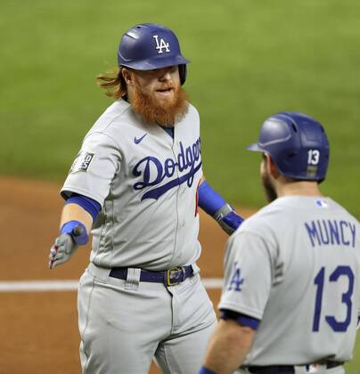 Baseball: World Series Justin Turner (L) of the Los Angeles Dodgers is congratulated by Max Muncy after hitting a solo home run in the first inning in Game 3 of the World Series against the Tampa Bay Rays on Oct. 23, 2020, at Globe Life Field in Arlington, Texas. 
