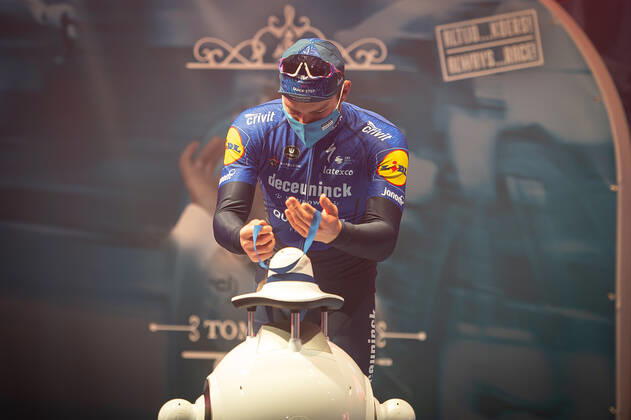 Radsport, E3 Harelbeke - Roboter führt Siegerehrung durch Zweiter - Florian Senechal (FRA - Deceuninck-Quick Step) bei der Siegerehrung - hier bei der Siegerzeremonie mit eigenstaendiger Uebernahme der Medaille von einem ferngesteuerten Roboter der die Ehrendamen Podiumsdamen Hostessen wegen der Covid-19 Corona Pandemie und der angemahnten Kontaktbeschraenkungen ersetzt - hier abgeschottet in der Sporthalle von Harelbeke ohne Zuschauer wegen der Covid-19 Corona Pandemie - Podium - Siegerehrung - Ehrung - Auszeichnung - Zeremonie - Zelebrierung - Ceremony - Jubel - Freude - Luck - Emotion - Emotionen - Mimik - Mimic - Gestik - Gestic - Querformat quer horizontal Event Veranstaltung: 64. E3 Saxo Bank Classic - Harelbeke nach to Harelbeke 203.9 km - Ort Location: Harelbeke - Region: West-Vlaanderen (Flandern) - Land Country: Belgien Belgium - Datum Date: 26.03.2021