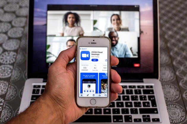 April 20, 2021, Barcelona, Catalonia, Spain: In this photo illustration, the Zoom app in App Store seen displayed on a smartphone screen and a Zoom Desktop on a laptop in the background. Barcelona Spain - ZUMAd159 20210420_zia_d159_091 Copyright: xThiagoxPrudenciox