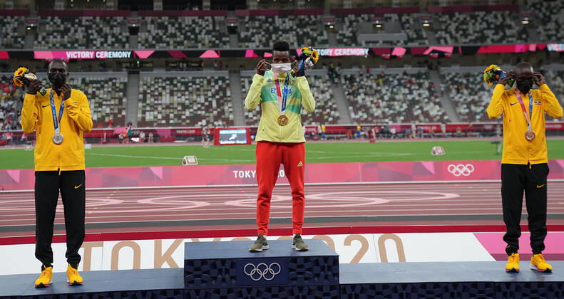 (210731) -- TOKYO, July 31, 2021 -- Gold medalist Selemon Barega (C) of Ethiopia, silver medalist Joshua Cheptegei (L) of Uganda and bronze medalist Jacob Kiplimo of Uganda react on the awarding ceremony of the men s 10000m at the Tokyo 2020 Olympic Games, Olympische Spiele, Olympia, OS in Tokyo, Japan, July 31, 2021. ) (TOKYO2020)JAPAN-TOKYO-OLY-ATHLETICS-MEN S 10000M-AWARDING CEREMONY LixYibo 