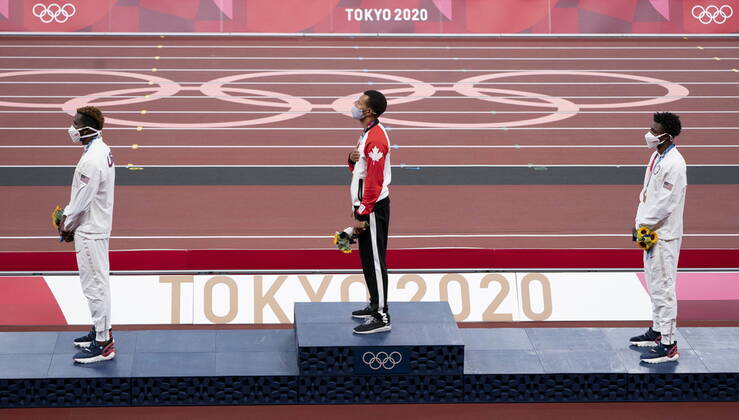 August 5, 2021, Tokyo, Japan: Canadaâ€⠢s Andre De Grasse, from Markham, Ont. stands on the podium with Kenny Bednarek (left) and Noah Lyles, from the United States, during the playing of the national anthem and receives the gold medal for the 200m race during a ceremony at the 2020 Tokyo Olympics, Thursday, August 5, 2021 in Tokyo, Japan. Canada News - August 5, 2021 - ZUMAc35_ 20210805_zaf_c35_011 Copyright: xAdrianxWyldx
