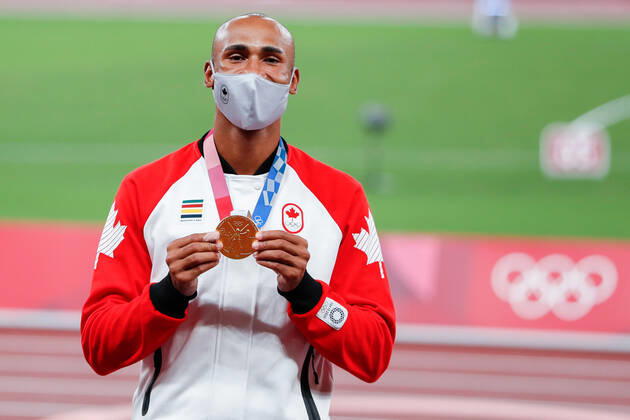 Men s decathlon gold medalist Damian Warner of Canada shows off his medal during the medal ceremony at Olympic Stadium at the 2020 Summer Olympics in Tokyo, Japan on Friday, August 6, 2021. Damian Warner of Canada took gold with 9018 points, Kevin Mayer of France took silver with 8726 points and Ashley Moloney of Australia took bronze with 8649 points.  OLY20210806410 TasosxKatopodis