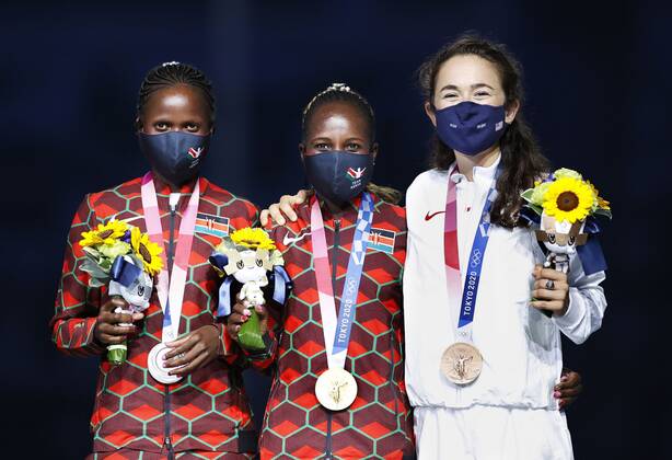 Tokyo Olympics: Athletics Tokyo Olympic women s marathon gold medalist Peres Jepchirchir (C) of Kenya poses for a photo at the victory ceremony held during the closing ceremony of the games at the National Stadium in Tokyo on Aug. 8, 2021, alongside compatriot Brigid Kosgei (L) and Molly Seidel of the United States, who took silver and bronze, respectively. They were wearing face masks for protection against the coronavirus.  A14AA0000757504P