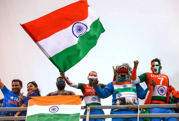 24th October 2021; Dubai International Cricket Stadium; Supporters of India wearing costumes yell and wave a national flag during the ICC Men s T20 World Cup match between India and Pakistan at Dubai International Cricket Stadium  ActionPlus12334161 DavidxGray