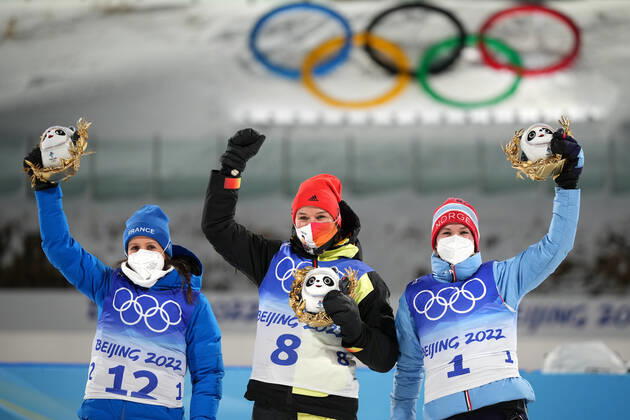 China Olympics 2022 Biathlon Women 8106981 07.02.2022 From left, silver medalist France s Anais Chevalier-Bouchet, gold medalist Germany s Denise Herrmann and bronze medalist Norway s Marte Olsbu Roeiseland celebrate on the podium during the flower ceremony for the biathlon women s 15 km individual competition during the Beijing 2022 Winter Olympic Games, Olympische Spiele, Olympia, OS at National Biathlon Centre in Zhangjiakou, China. Ramil Sitdikov Sputnik Zhangjiakou China  Copyright: xRamilxSitdikovx