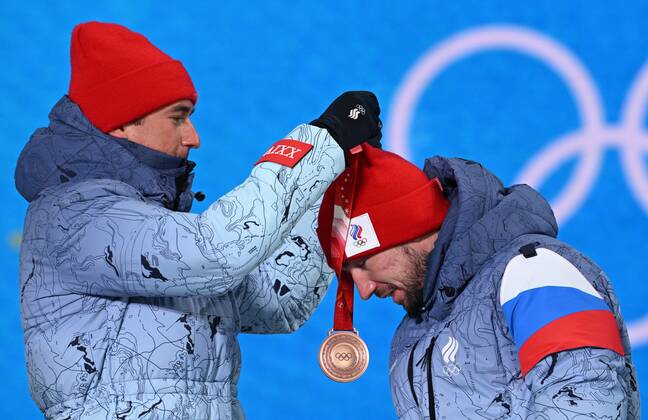 BEIJING 2022, Biathlon, 4x7,5km Staffel M?nner, Siegerehrung China Olympics 2022 Medal Ceremony 8116938 16.02.2022 Bronze medalist Russian Olympic Committee s Said Karimulla Khalili helps his teammate Alexander Loginov to put on his medal during an award ceremony for the biathlon men s 4x7.5 km relay event during the Beijing 2022 Winter Olympic Games, Olympische Spiele, Olympia, OS at the Medals Plaza in Zhangjiakou, China. Alexey Filippov Sputnik Beijing China  Copyright: xAlexeyxFilippovx