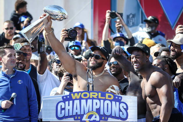 LOS ANGELES, CA - FEBRUARY 16: Los Angeles Rams defensive end Aaron Donald 99 holds the Lombardi Trophy with Los Angeles Rams linebacker Obo Okoronkwo 45 smiling during the Los Angeles Rams Super Bowl LVI Championship parade on February 16, 2022, at the Los Angeles Memorial Coliseum in Los Angeles, CA. (Photo by Jevone Moore Icon Sportswire) NFL, American Football Herren, USA FEB 16 Rams Super Bowl LVI Championship Parade Icon2202160687