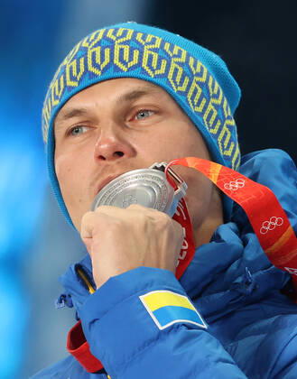 ZHANGJIAKOU, CHINA - FEBRUARY 17, 2022: Silver medallist Oleksandr Abramenko of Ukraine bites his medal during the victory ceremony for the men s freestyle skiing aerials, at the Medal Plaza, at the 2022 Winter Olympic Games, Olympische Spiele, Olympia, OS Stanislav Krasilnikov TASS  TS123D42