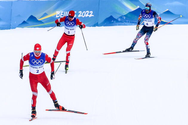 ZHANGJIAKOU, CHINA - FEBRUARY 19, 2022: Skiers Alexander Bolshunov of Team ROC, Ivan Yakimushkin of Team ROC, and Simen Hegstad Krueger (L-R) of Norway compete to win gold, silver, and bronze respectively in the men s 30km cross-country skiing mass start race during the Beijing 2022 Winter Olympic Games, Olympische Spiele, Olympia, OS at the Zhangjiakou National Cross-Country Skiing Centre. The men s 50km cross-country skiing mass start race has been shortened to 30km due to weather conditions. Stanislav Krasilnikov TASS  TS1243BB