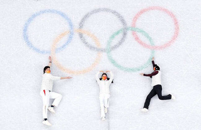 Sport Bilder des Tages (220219) -- BEIJING, Feb. 19, 2022 -- China s Ice dancing, Eistanzen pair of Liu Xinyu and Wang Shiyue, Chinese figure skater Jin Boyang (L to R) lie on the ice rink to pose for a photo with the Olympic Rings in the background after the Figure skating, Eiskunstlauf pair skating free skating of the Beijing 2022 Winter Olympics at Capital Indoor Stadium in Beijing, capital of China, Feb. 19, 2022. ) (BEIJING2022)CHINA-BEIJING-OLYMPIC Winter games, Winterspiele,Spiele, Summer games FIGURE SKATING-PAIR SKATING-FREE SKATING (CN) MaxNing