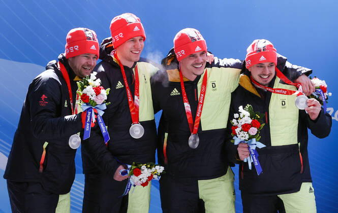 BEIJING, CHINA - FEBRUARY 20, 2022: Silver medalists Johannes Lochner, Florian Bauer, Christopher Weber, and Christian Rasp of Germany at a flower ceremony for the 4-man bobsleigh at the 2022 Winter Olympic Games, Olympische Spiele, Olympia, OS at the Yanqing National Sliding Centre. Anton Novoderezhkin TASS  TS1247E5