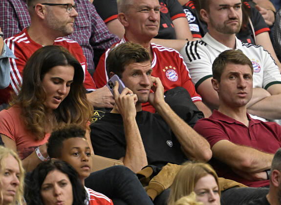 29.10.2022, Fussball 1. Bundesliga 2022 2023, 12.Spieltag, FC Bayern München - 1.FSV Mainz 05, in der Allianz-Arena München. mitte: Thomas Müller (FC Bayern München) telefoniert auf der Tribüne , li: Frau Lisa, rechts Bruder Simon Müller.