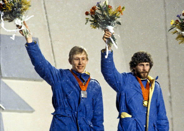 ARKIV 1984-02-19 Silvermedaljören Gunde Svan och guldmedaljören Thomas Wassberg vinkar med blomsterkvastarna i händerna och sina medaljer runt halsen under medaljceremonin för 50 km längdskidakning vid de olympiska vinterspelen i Sarajevo, Jugoslavien 19:e februari 1984. Sarajevo Bosnia-Hercegovina x193x