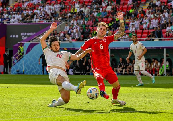 Wales v Iran 2022 FIFA World Cup, WM, Weltmeisterschaft, Fussball 25 11 2022. Match 17 Sardar Azmoun (20) of Iran streches for the ball on goal defended by Joe Rodon (6) of Wales during the 2022 Fifa World Cup match between Wales and Iran at Ahmad bin Ali Stadium, Al Rayyan, Qatar on 25 November 2022. Editorial use only , Copyright: xNigelxKeenex PSI-16408-0014