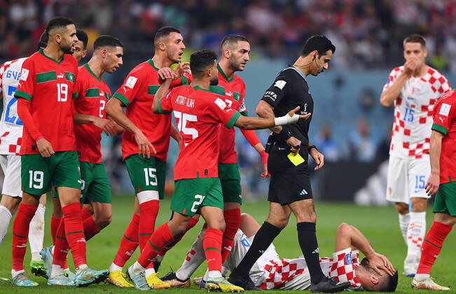 FUSSBALL WM 2022 Spiel um Platz 3 Kroatien - Marokko 17.12.2022 Schiedsrichter Abdulrahman Al Jassim (Katar) wird von Hakim Ziyech, Yahia Attiat Allah, Selim Amallah, Achraf Hakimi und Youssef En-Nesyri (v.re, alle Marokko) nach einer Entscheidung auf Freistoss nach einem Foul an Bruno Petkovic (Boden, Kroatien) bedraengt.