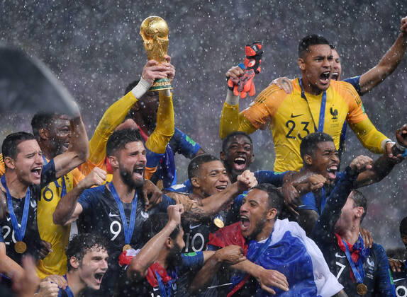 ARCHIVBILD FUSSBALL WM 2018 Finale 15.07.2018 Frankreich - Kroatien Siegerehrung Weltmeister Frankreich im Regen; Forian Thauvin, Torwart Steve Mandanda, Torwart Hugo Lloris mit WM Pokal, Olivier Giroud, Kylian Mbappe, Ousmane Dembele, Torwart Alphonse Areola, Presnel Kimpembe (hinter reihe v.li.) Benjamin Pavard , Nabil Fekir, Corentin Tolisso und Antoine Griezmann (vorn v.li.)