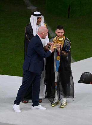 FUSSBALL WM 2022 Finale Argentinien - Frankreich 18.12.2022 Lionel Messi nimmt im Umhang (Bischt) den WM Pokal von Tamim bin Hamad Al Thani (Emir von Katar) und Fifa-Praesident Gianni Infantino entgegen