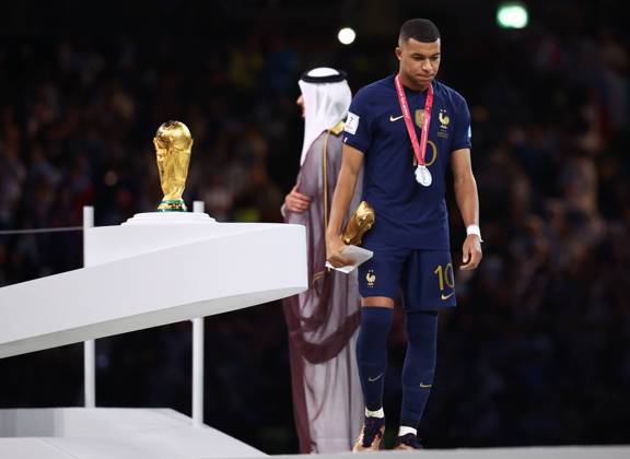 Doha, Qatar, 18th December 2022. Kylan Mbappe of France walks past the World Cup as he collects his Golden Boot award during the FIFA World Cup, WM, Weltmeisterschaft, Fussball 2022 match at Lusail Stadium, Doha. Picture credit should read: David Klein Sportimage EDITORIAL USE ONLY. No use with unauthorised audio, video, data, fixture lists, club league logos or live services. Online in-match use limited to 120 images, no video emulation. No use in betting, games or single club league player publications. SPI-2101-0235