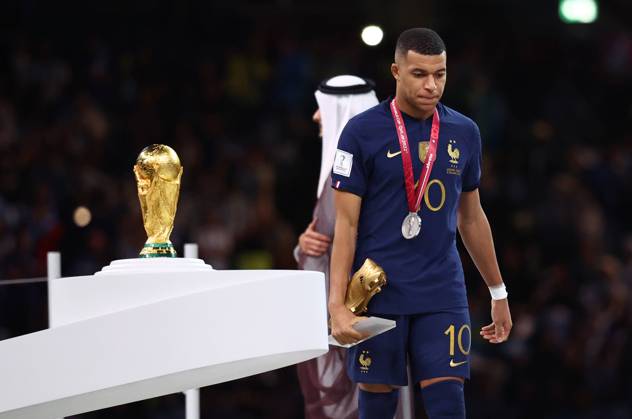 Doha, Qatar, 18th December 2022. Kylan Mbappe of France walks past the World Cup as he collects his Golden Boot award during the FIFA World Cup, WM, Weltmeisterschaft, Fussball 2022 match at Lusail Stadium, Doha. Picture credit should read: David Klein Sportimage EDITORIAL USE ONLY. No use with unauthorised audio, video, data, fixture lists, club league logos or live services. Online in-match use limited to 120 images, no video emulation. No use in betting, games or single club league player publications. SPI-2101-0236