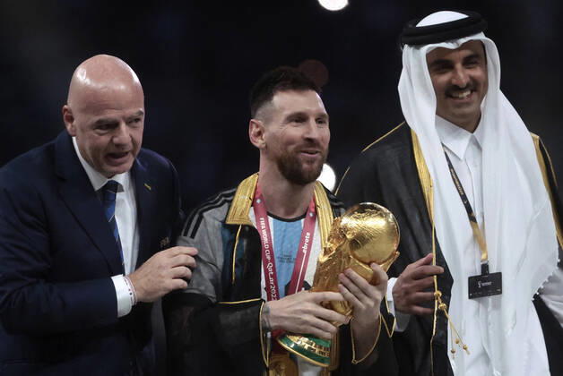 Lionel Messi (C) from Argentina poses with the World Cup trophy together with FIFA President Giovanni Vincenzo (L) and the Emir of the State of Qatar in the final of the FIFA World Cup, WM, Weltmeisterschaft, Fussball soccer tournament between Argentina and France at Lusail stadium in Lusail, Qatar, 18 December 2022. Soccer World Cup 2022: Argentina - France !ACHTUNG: NUR REDAKTIONELLE NUTZUNG! Copyright: xJuanxIgnacioxRoncoronix GR7418 20221218-c1c4d3cdec010670b68b3bff8c6d4cdef490a3ec