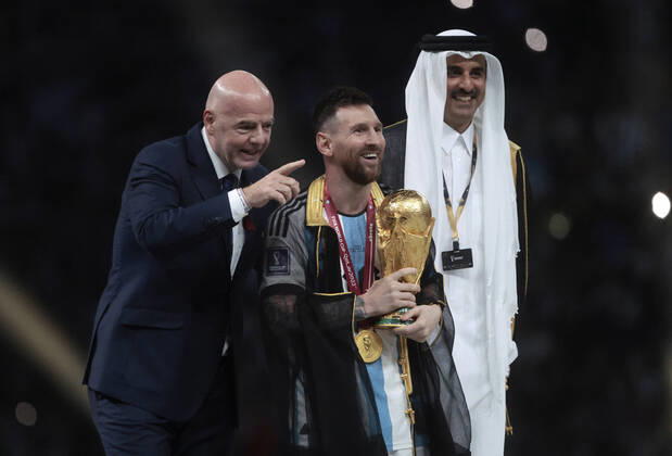 Lionel Messi (C) from Argentina poses with the World Cup trophy together with FIFA President Giovanni Vincenzo (L) and the Emir of the State of Qatar in the final of the FIFA World Cup, WM, Weltmeisterschaft, Fussball soccer tournament between Argentina and France at Lusail stadium in Lusail, Qatar, 18 December 2022. Soccer World Cup 2022: Argentina - France !ACHTUNG: NUR REDAKTIONELLE NUTZUNG! Copyright: xJuanxIgnacioxRoncoronix GR7407 20221218-59e6aede2803dc595adae9f9a2be5299231e2b11