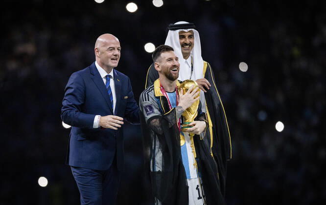 Doha, Qatar. 18th Dec, 2022. Lionel Messi of Argentina carries the FIFA World Cup, WM, Weltmeisterschaft, Fussball Qatar 2022 Winner s Trophy as Gianni Infantino, President of FIFA, and Sheikh Tamim bin Hamad Al Thani, Emir of Qatar, look on during the FIFA World Cup Qatar 2022 Final match between Argentina - France Final Match Argentinien - Frankreich World Cup 2022 in Qatar 18.12.2022